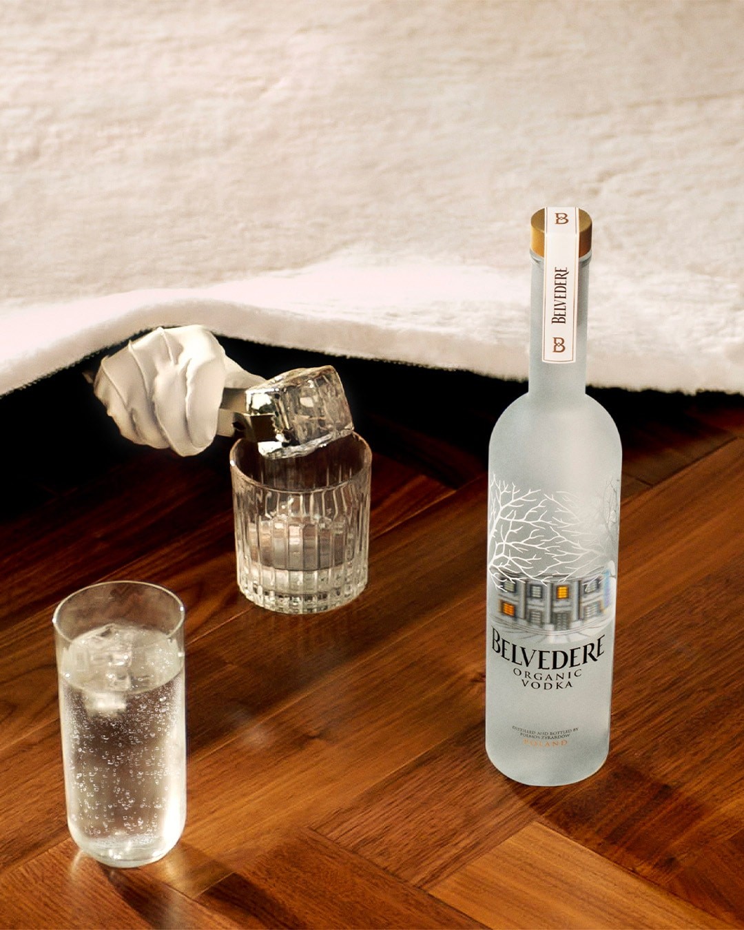 Belvedere Organic bottle with two glasses and a gloved hand serving ice on a glass - desktop