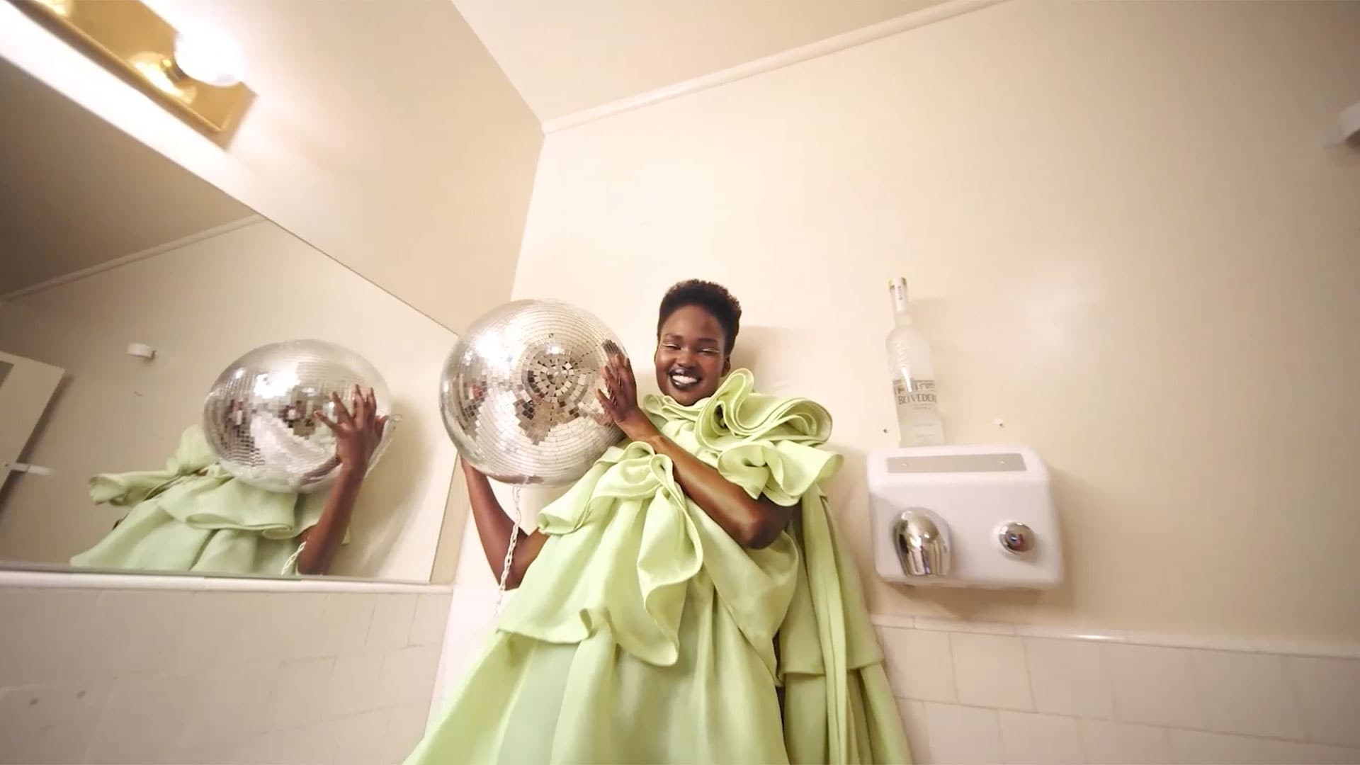 Belvedere and Tyler Mitchell - Woman in a bathroom holding a disco ball - desktop version